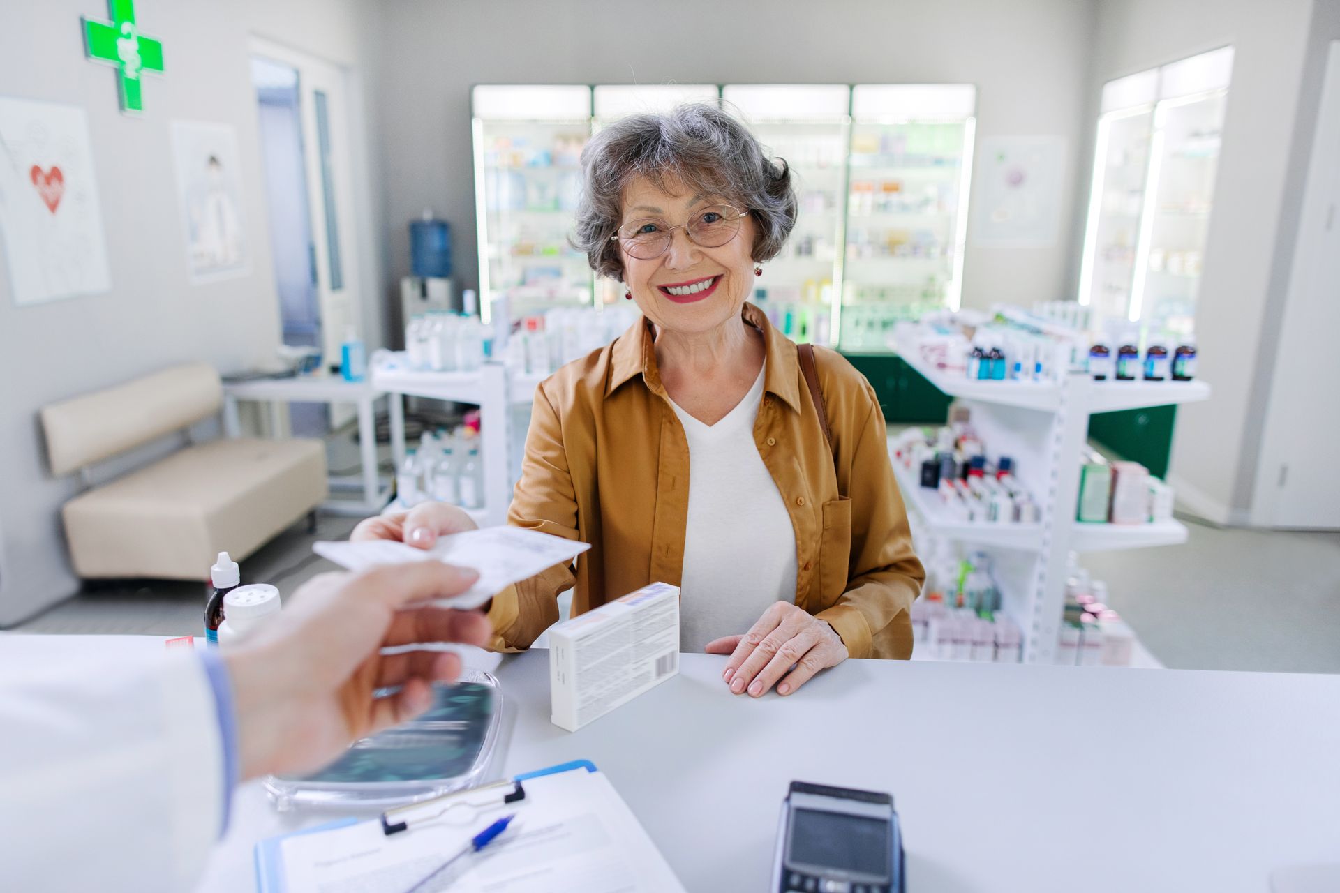 Smiling customer at pharmacy counter, receiving a card from a pharmacist in a bright store