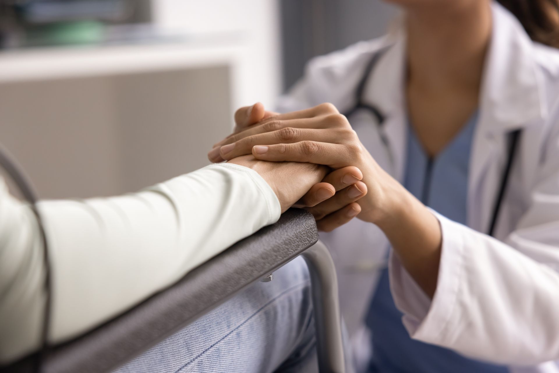 Doctor holding a patient’s hand in a hospital setting