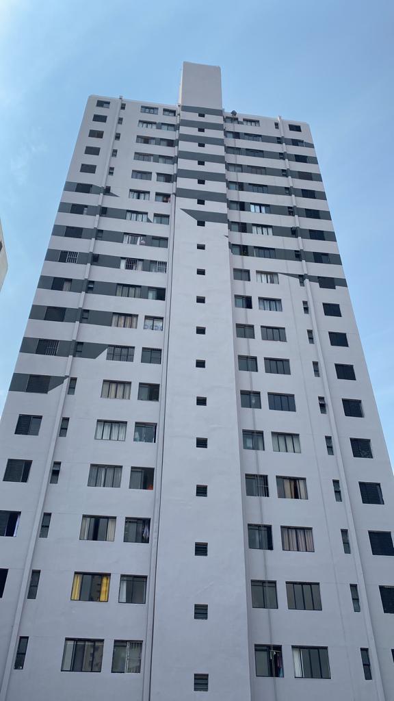 Um prédio alto e branco com um céu azul ao fundo