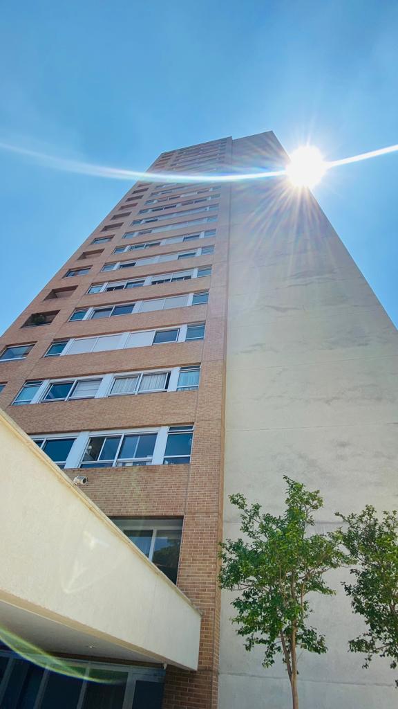 O sol está brilhando através das janelas de um prédio alto.