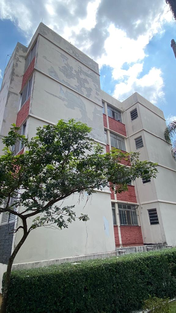 Um grande edifício com uma árvore na frente.