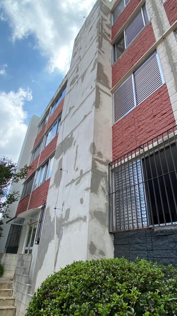 Um grande edifício de tijolos com uma parede branca e escadas na frente.