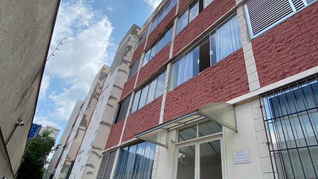 Um grande edifício de tijolos com muitas janelas e um dossel.