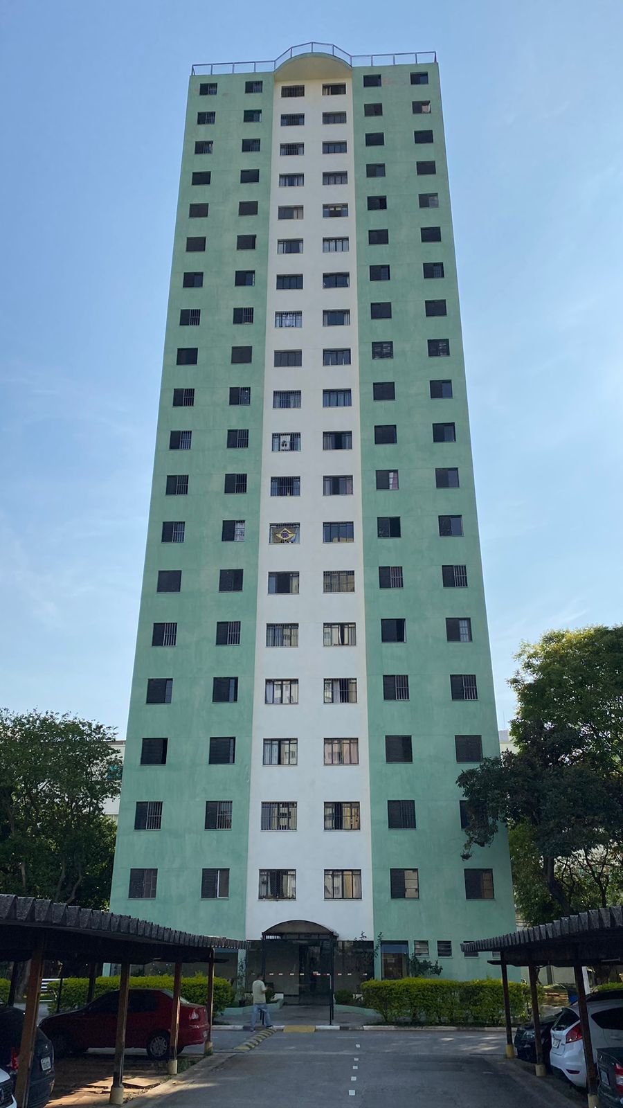 Um prédio alto verde e branco com muitas janelas