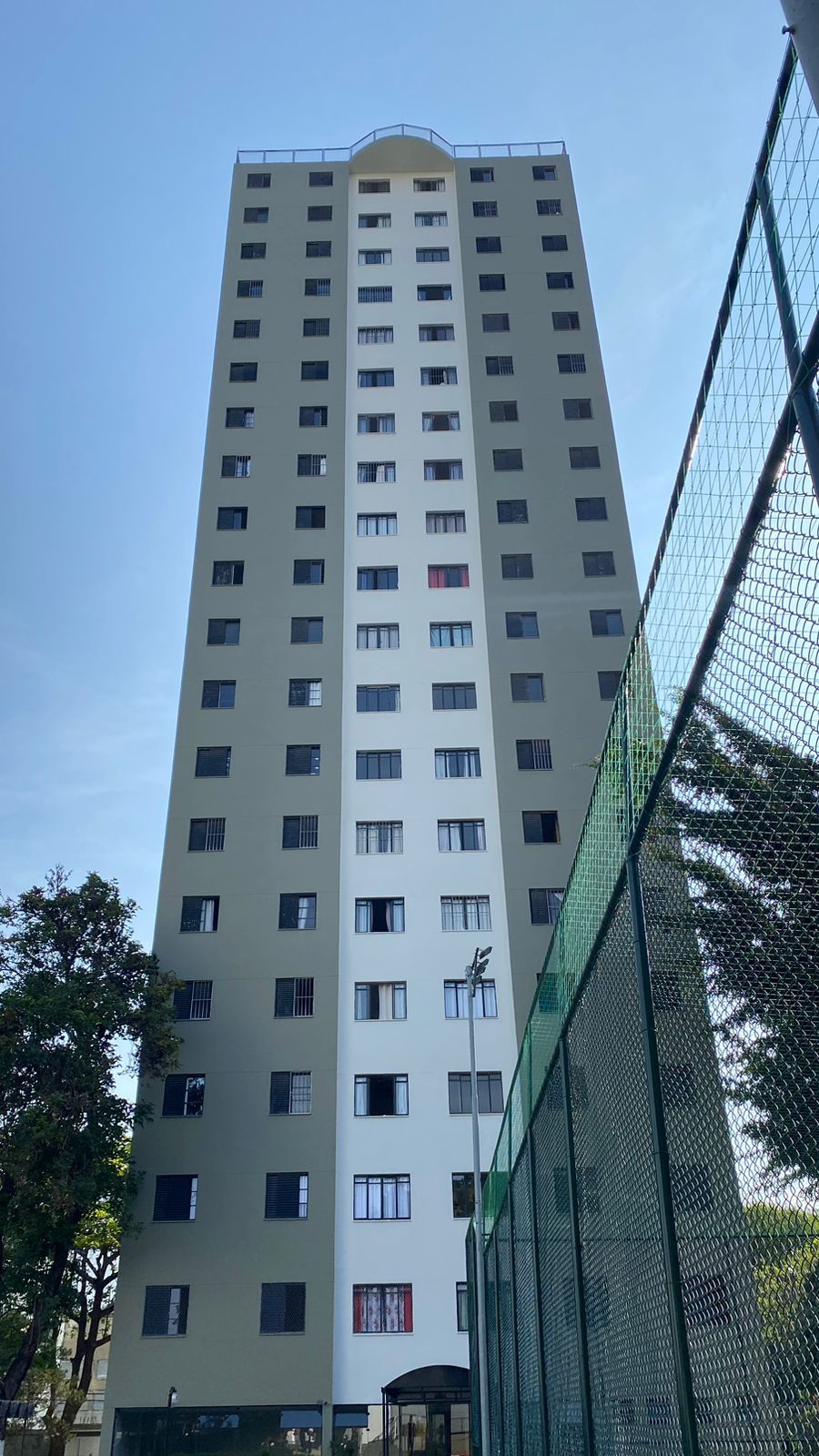 Um prédio alto com uma cerca na frente
