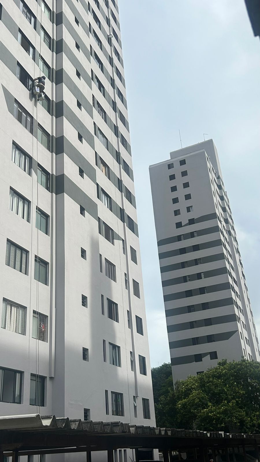Um homem está limpando as janelas de um prédio alto.