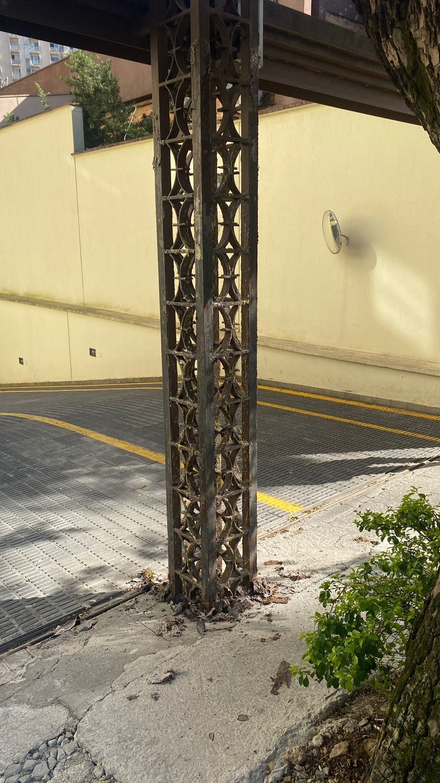 Um poste de metal está no meio de um estacionamento.