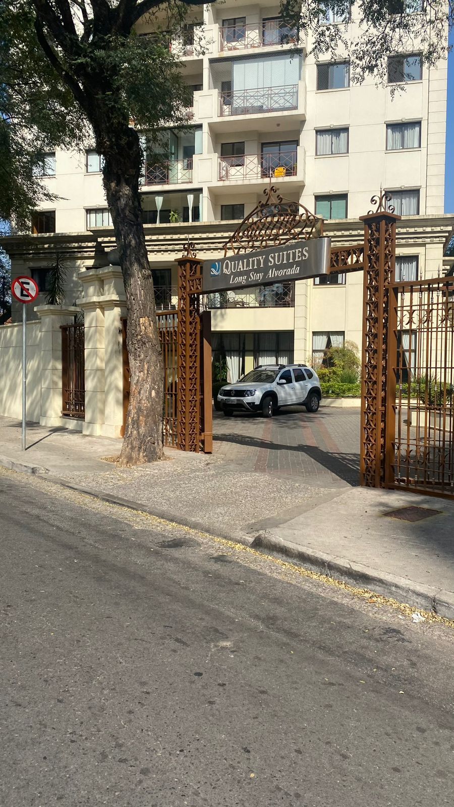 Um carro branco está estacionado em frente a um prédio.