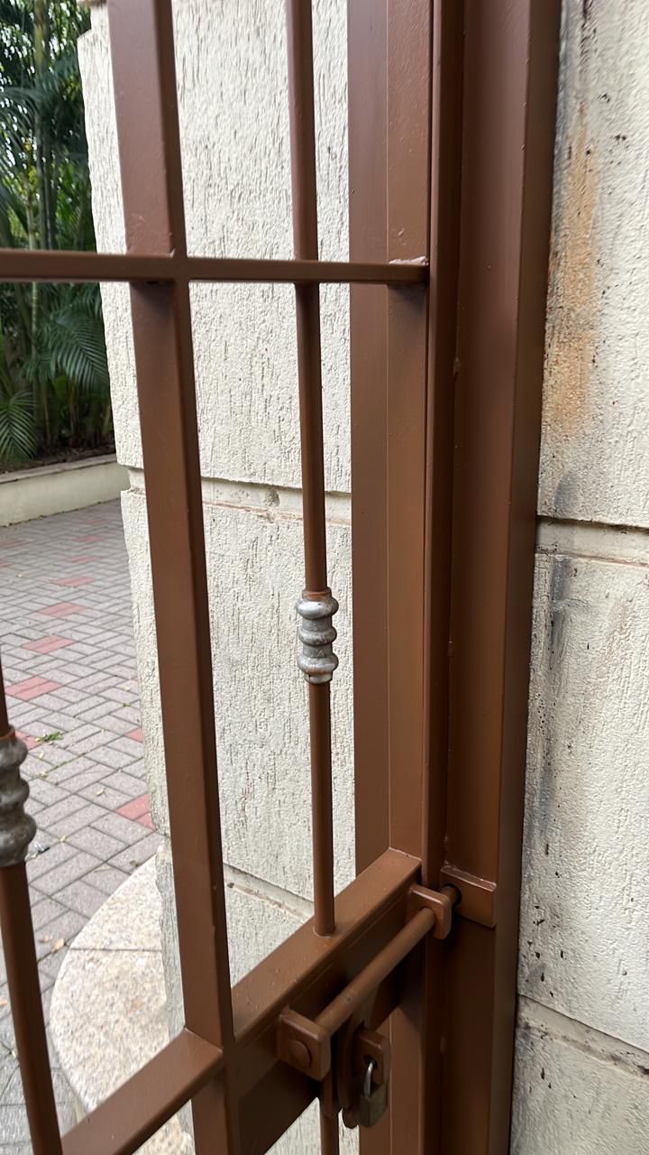 Um close de um portão de ferro forjado em uma parede de tijolos.