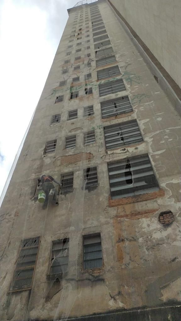 Olhando para um prédio alto com muitas janelas.