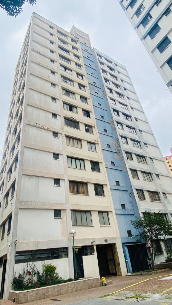 Um prédio alto com muitas janelas e um hidrante na frente.