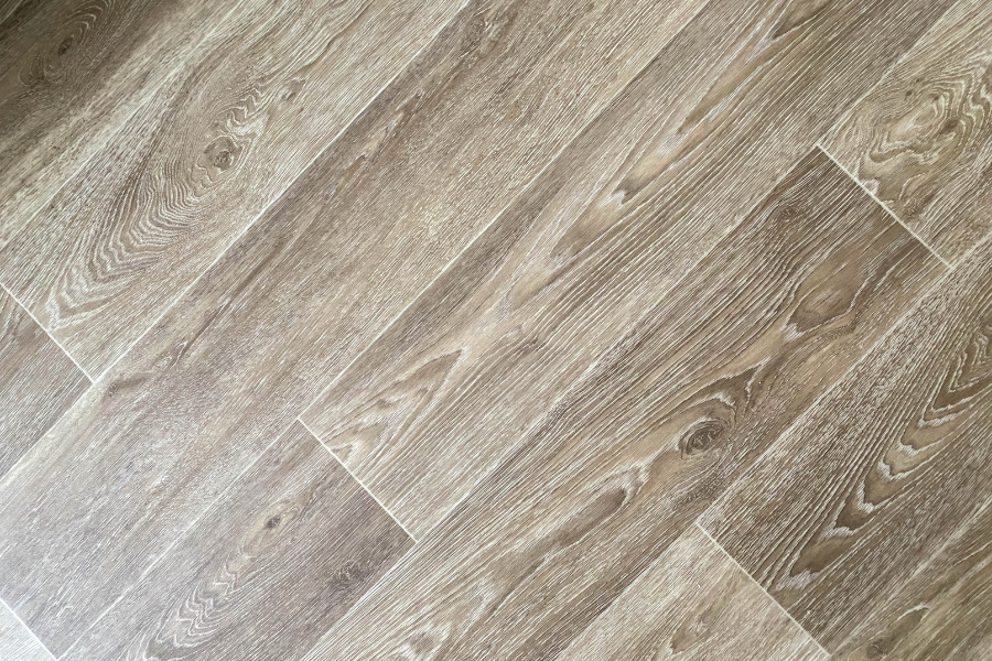 A close up of a wooden floor with a diagonal pattern.