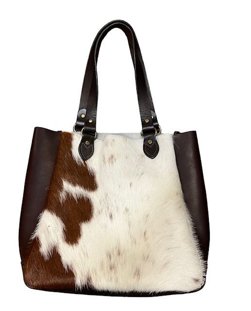 Cowhide tote bag with brown leather accents and handles.