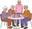 Four seniors smiling around a pink board game at a round table, with cups in a cozy room