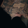 Hand holding an old folded map at night, lit by warm streetlights
