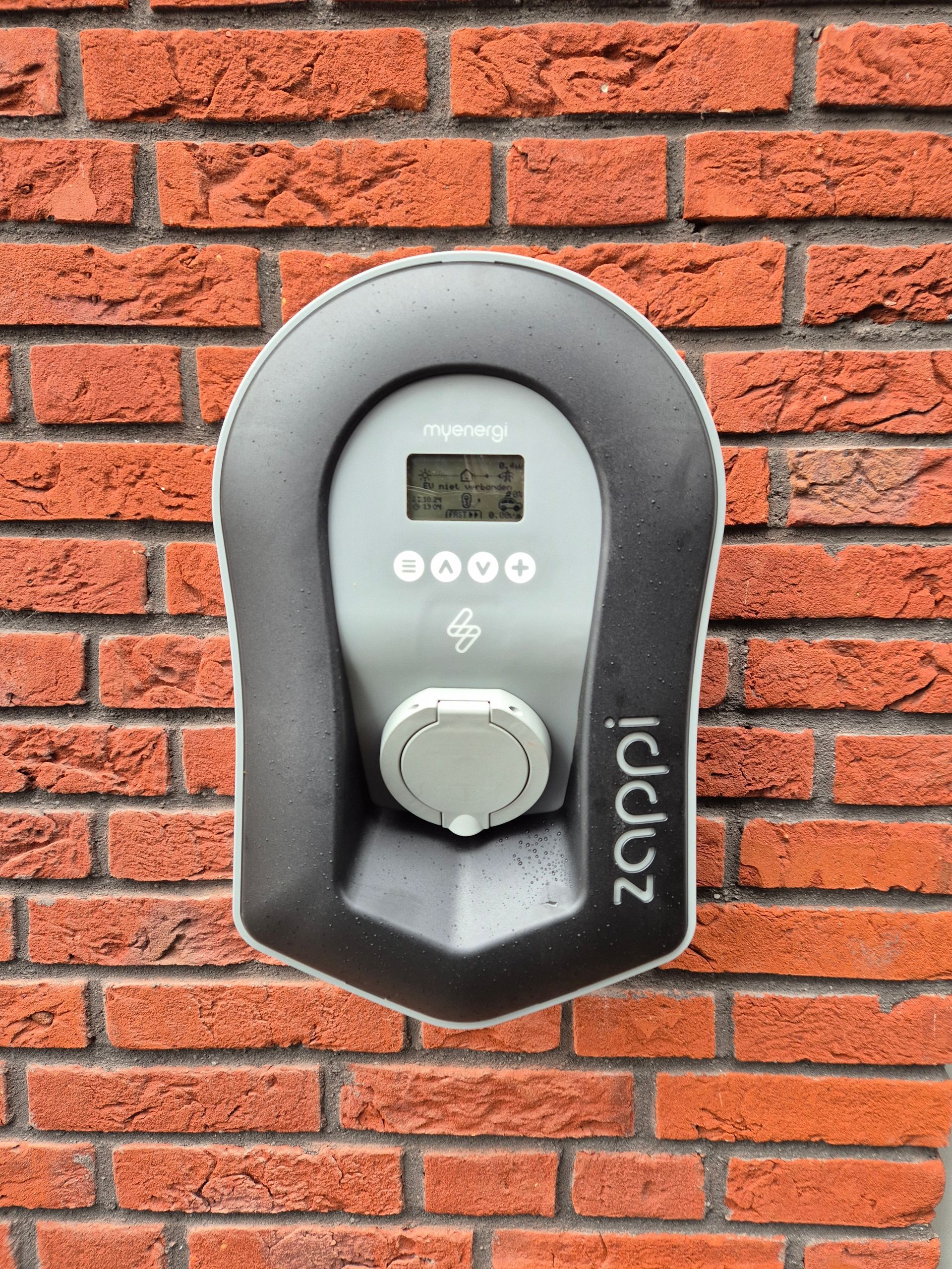 Door 3-Fasen geïnstalleerde myenergi Zappi laadpaal op een bakstenen gevel