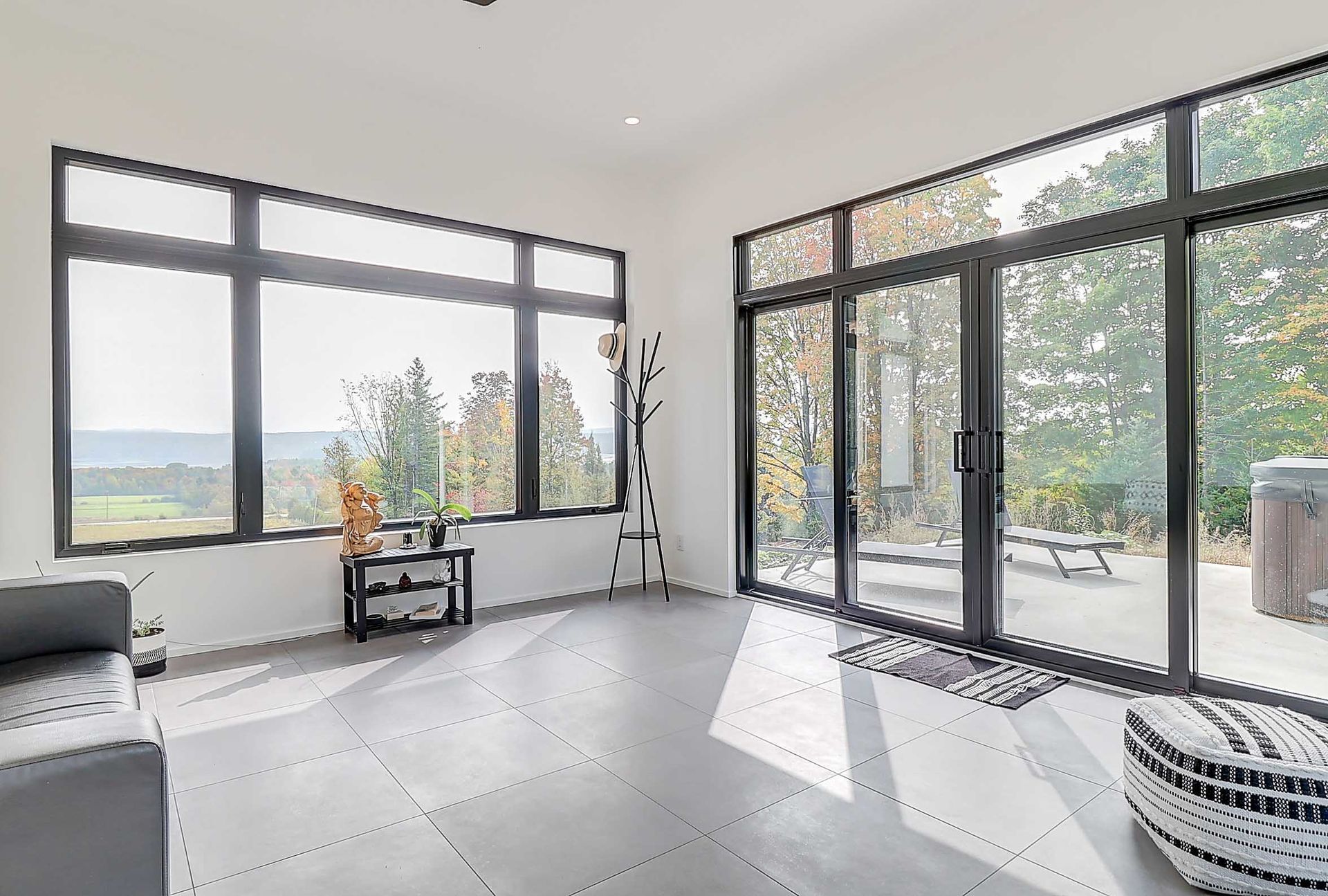Cette chambre lumineuse et moderne est dot&eacute;e d'un sol carrel&eacute;, de grandes fen&ecirc;tres avec vue, de portes-fen&ecirc;tres et d'un mobilier contemporain.