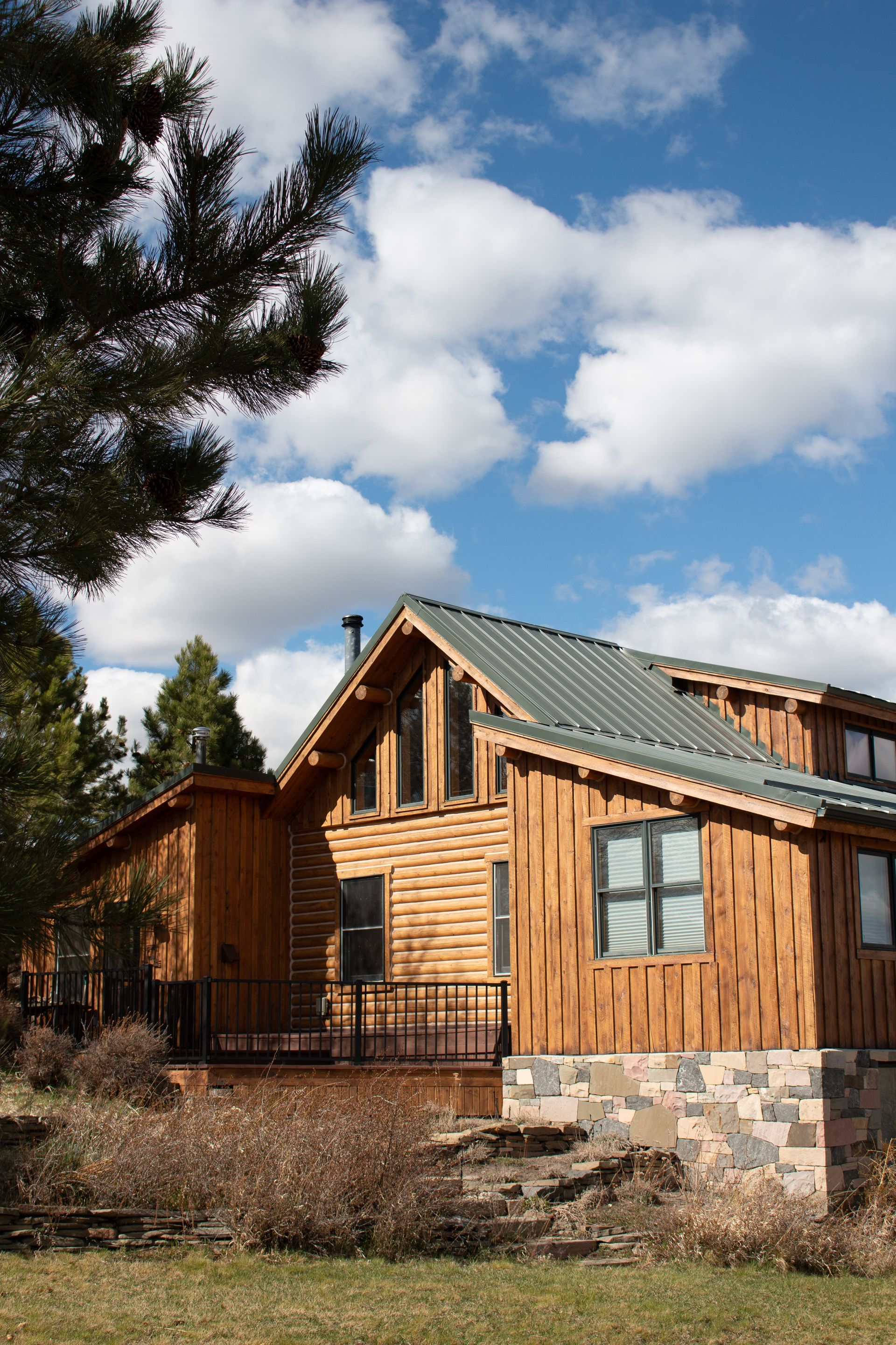 Rustic log cabin with a steep shingled roof in a snowy mountain landscape