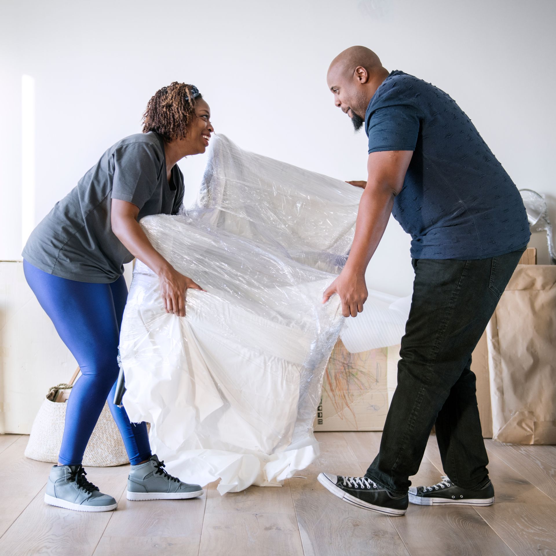 A man and a woman are holding a large piece of plastic.