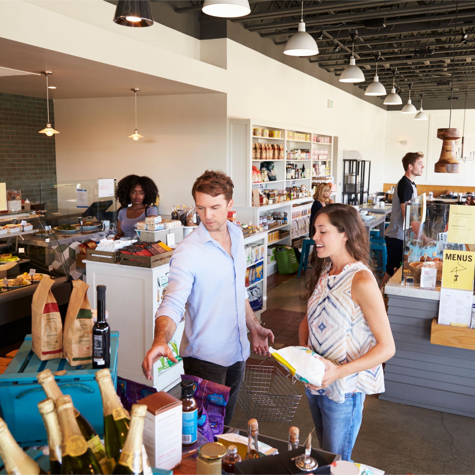A man and a woman are standing in a store talking to each other
