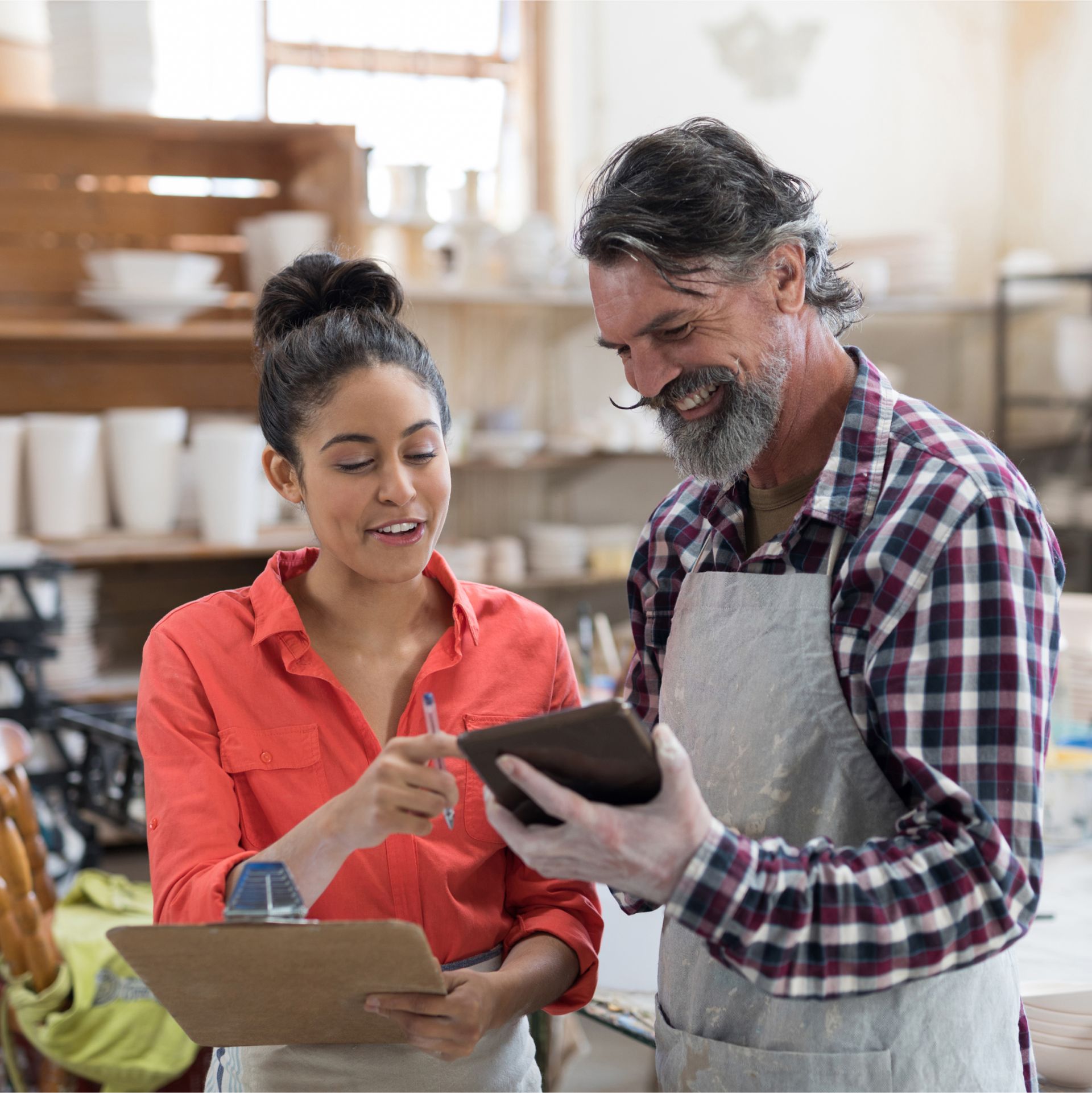 A man and a woman are looking at a tablet together.
