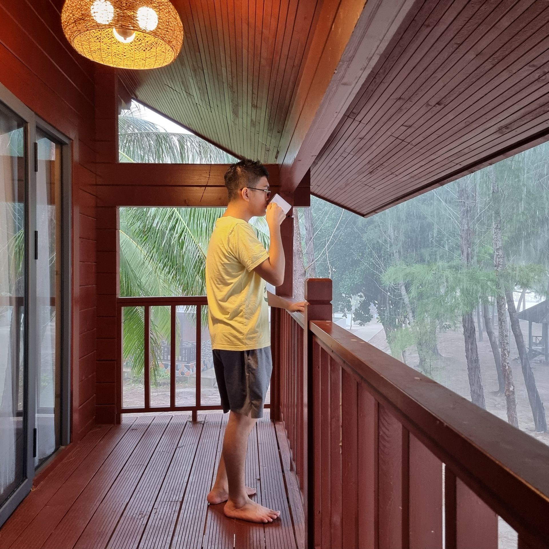 A man standing on a balcony reading a book