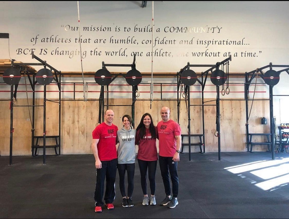 A group of people are posing for a picture in a gym.
