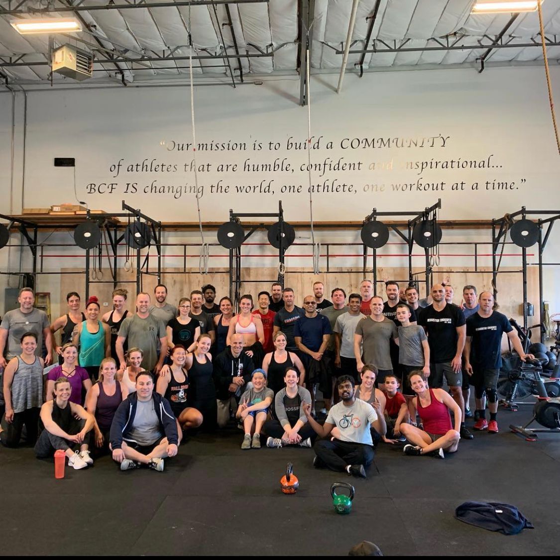 A group of people are posing for a picture in a gym.
