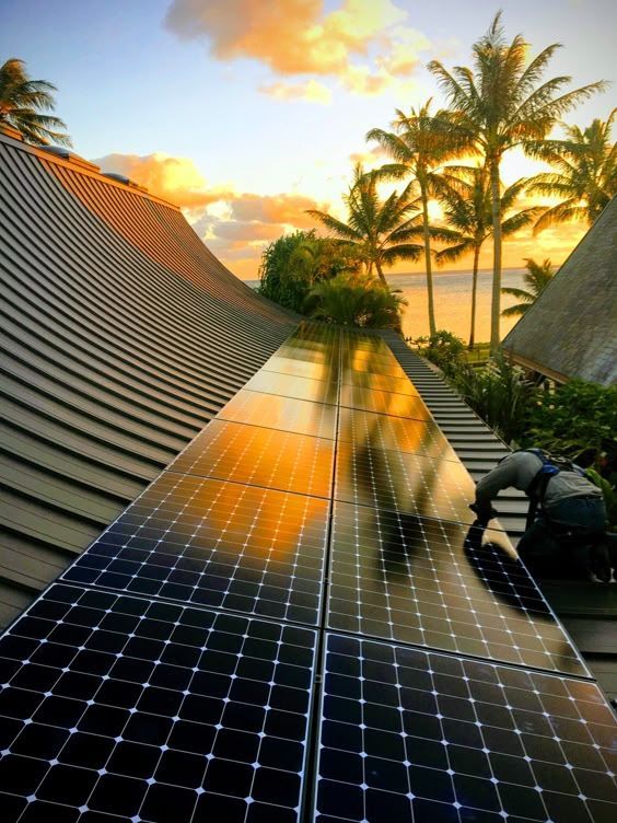 Un hombre está instalando paneles solares en el techo de un edificio.