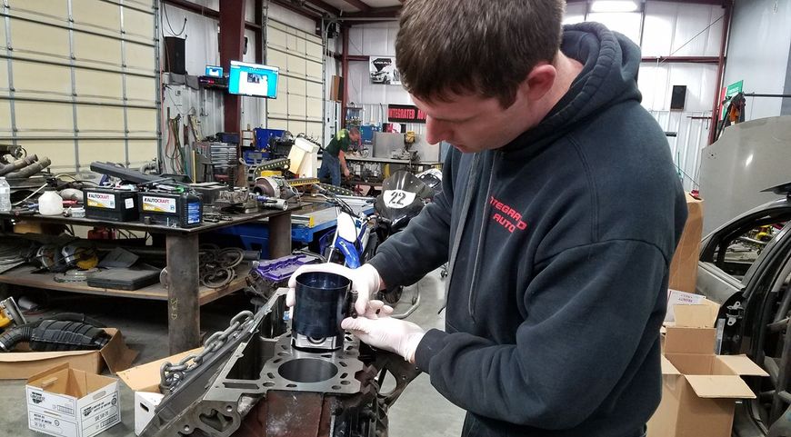 Our certified mechanic installs a piston into an engine block in Sanford, NC | Integrated Automotive