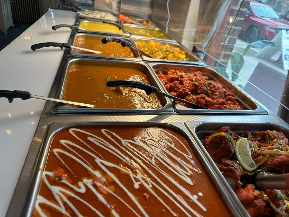 Buffet with various Indian dishes in serving trays.