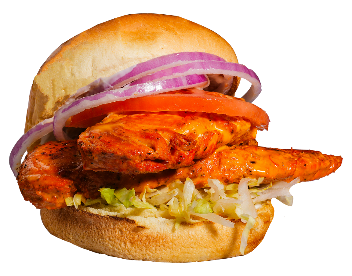 Chicken sandwich with red onion, tomato, and lettuce on a bun.