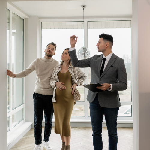 A group of people are standing in a room looking at a window.