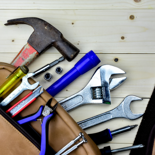 A bag full of tools including a hammer and wrench