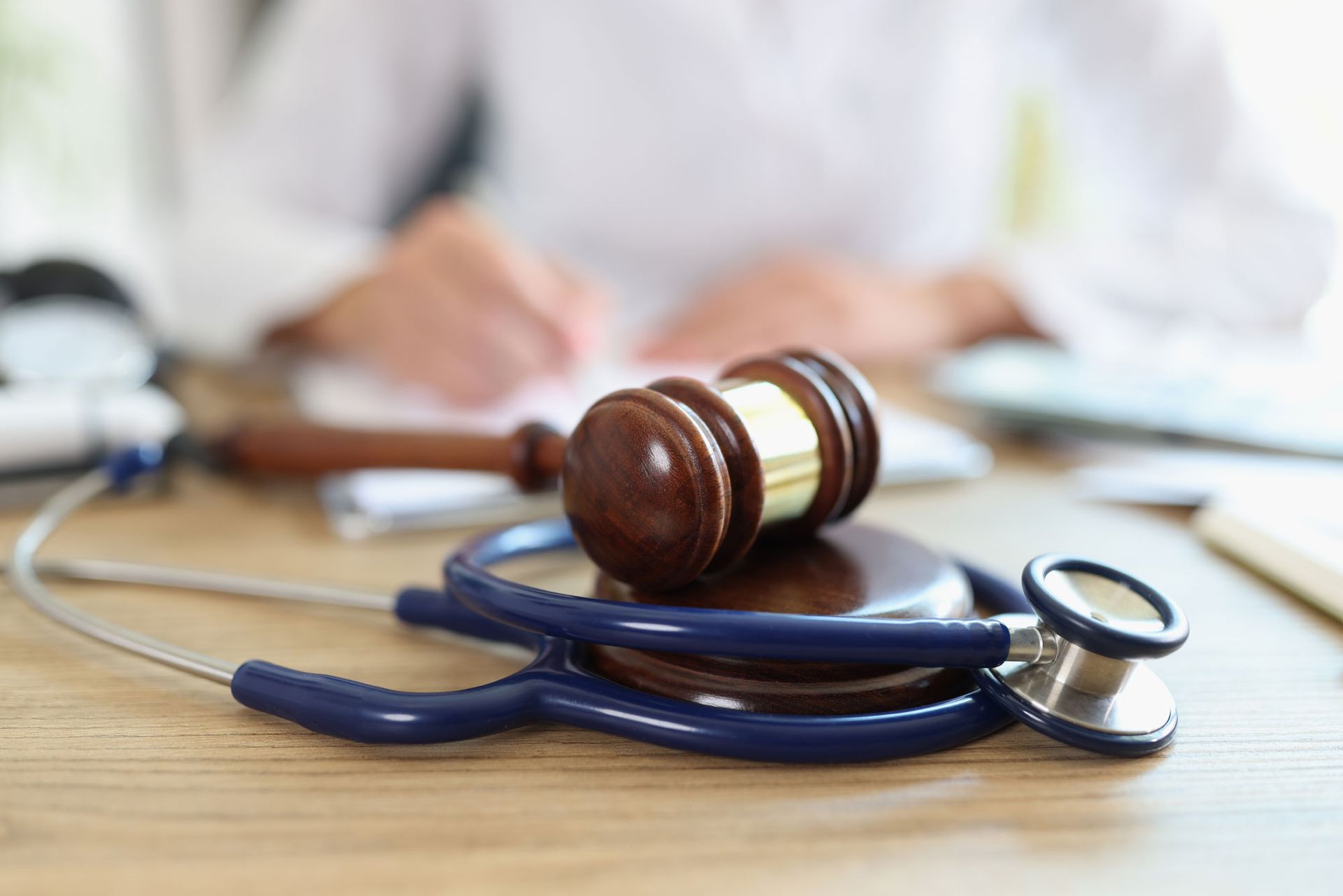 Close-up of judge hammer and doctor stethoscope on office desk