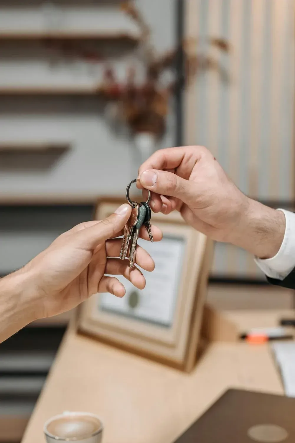 A man is handing a woman a set of keys.
