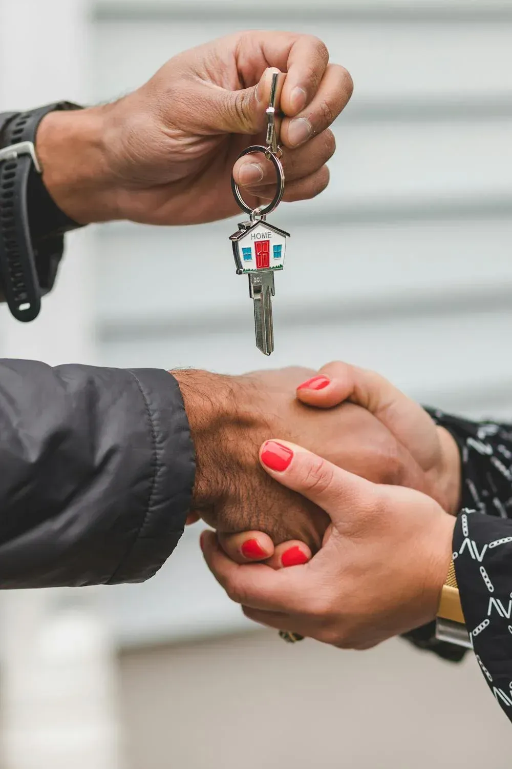 A man is handing a woman a set of keys.