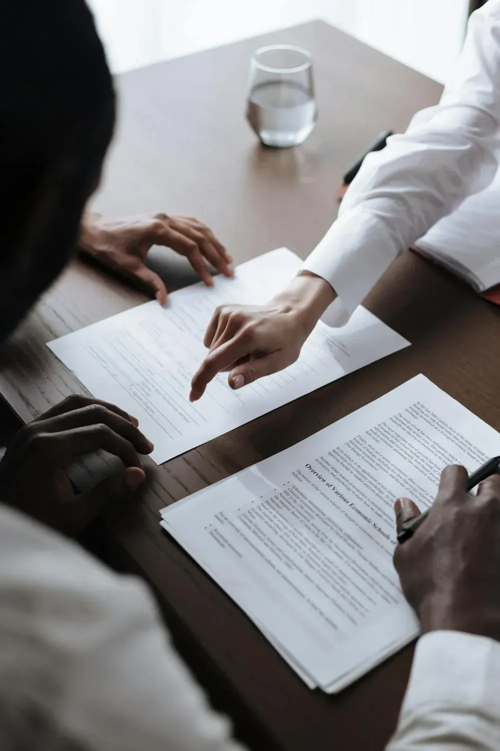 Two people are sitting at a table looking at papers.