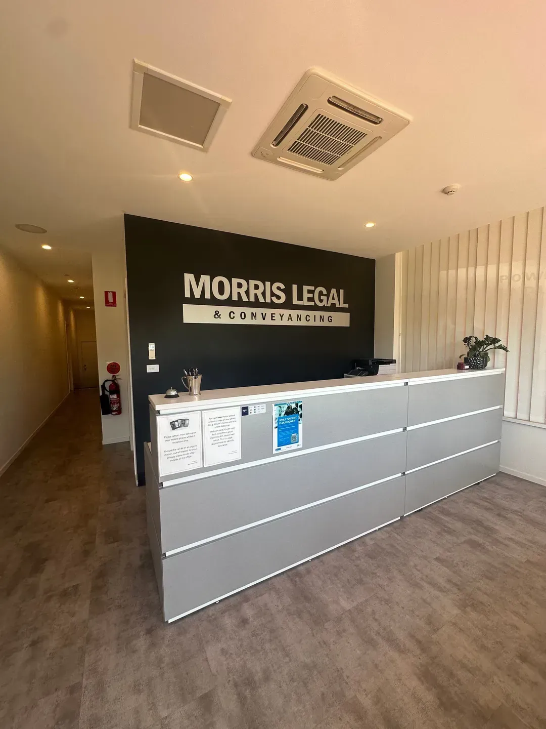 A Reception Desk With Morris Legal & Conveyancing Sign on a Wall