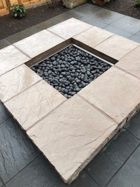 A fire pit made of tiles and rocks on a patio