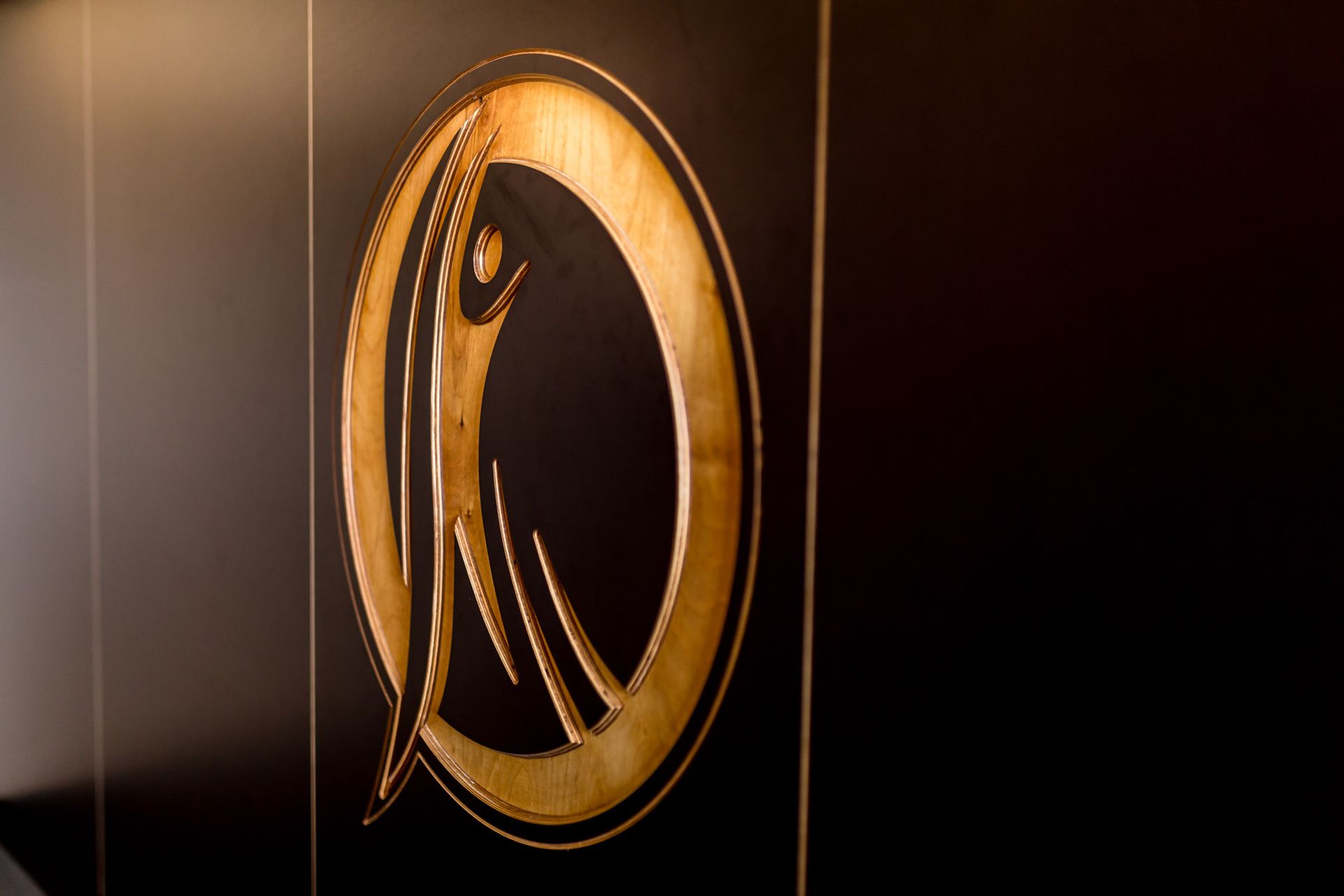 Eine schwarze Wand mit einem goldenen Logo darauf