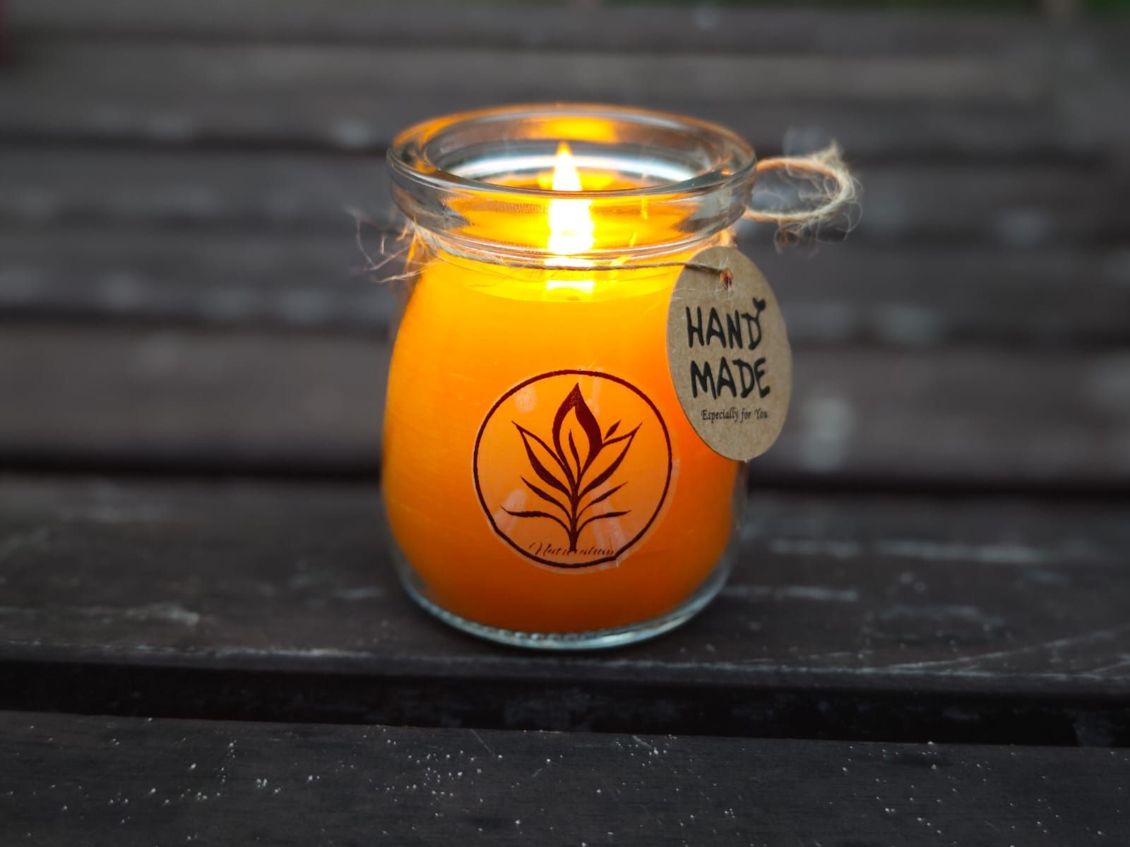 Brandende 100% bijenwas kaars in een glazen pot met het label 