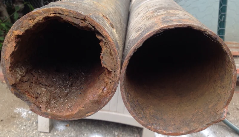 Ted & Bros Plumbing | person is painting an orange pipe with a roller