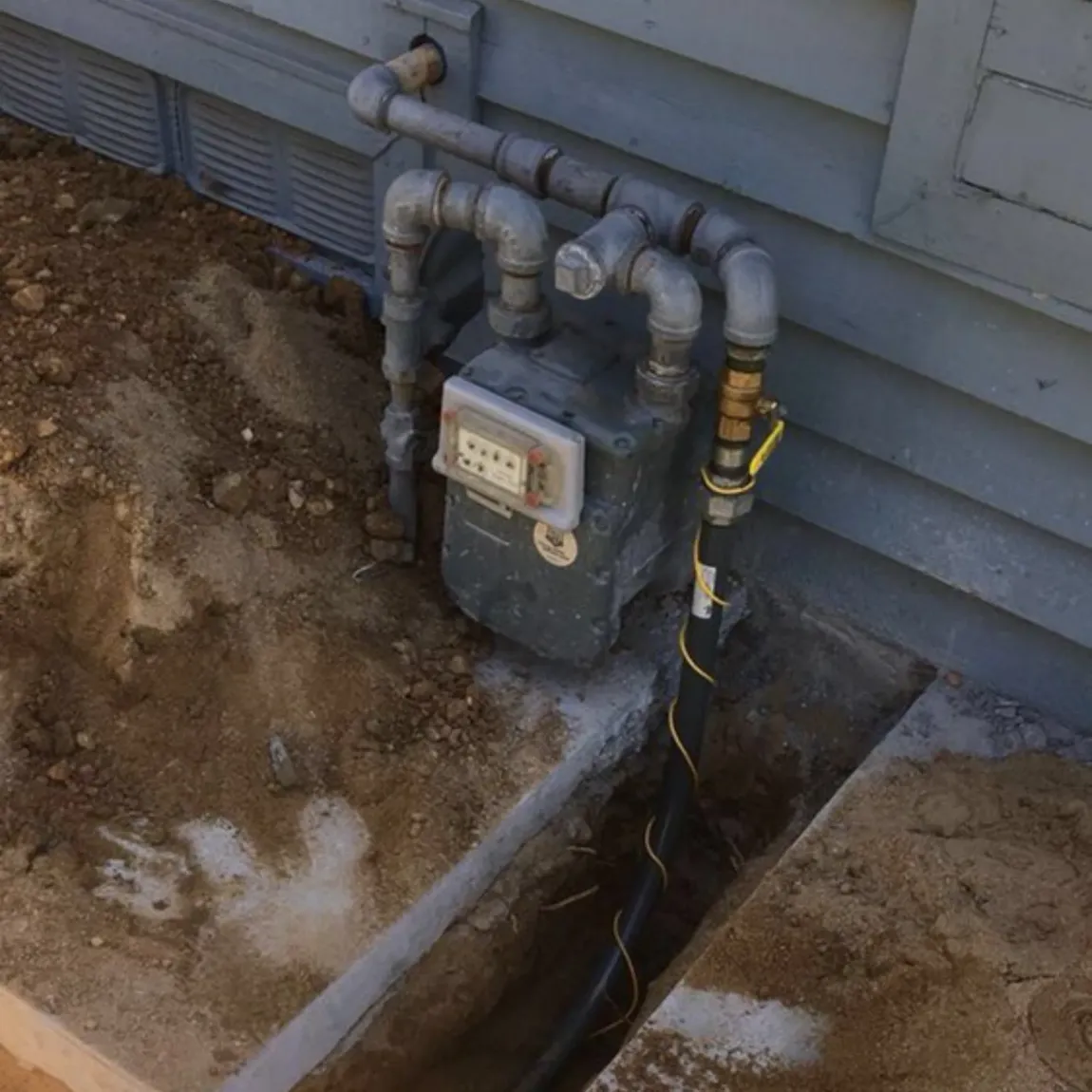Ted & Bros Plumbing | gas meter is sitting on the side of a house& Bros