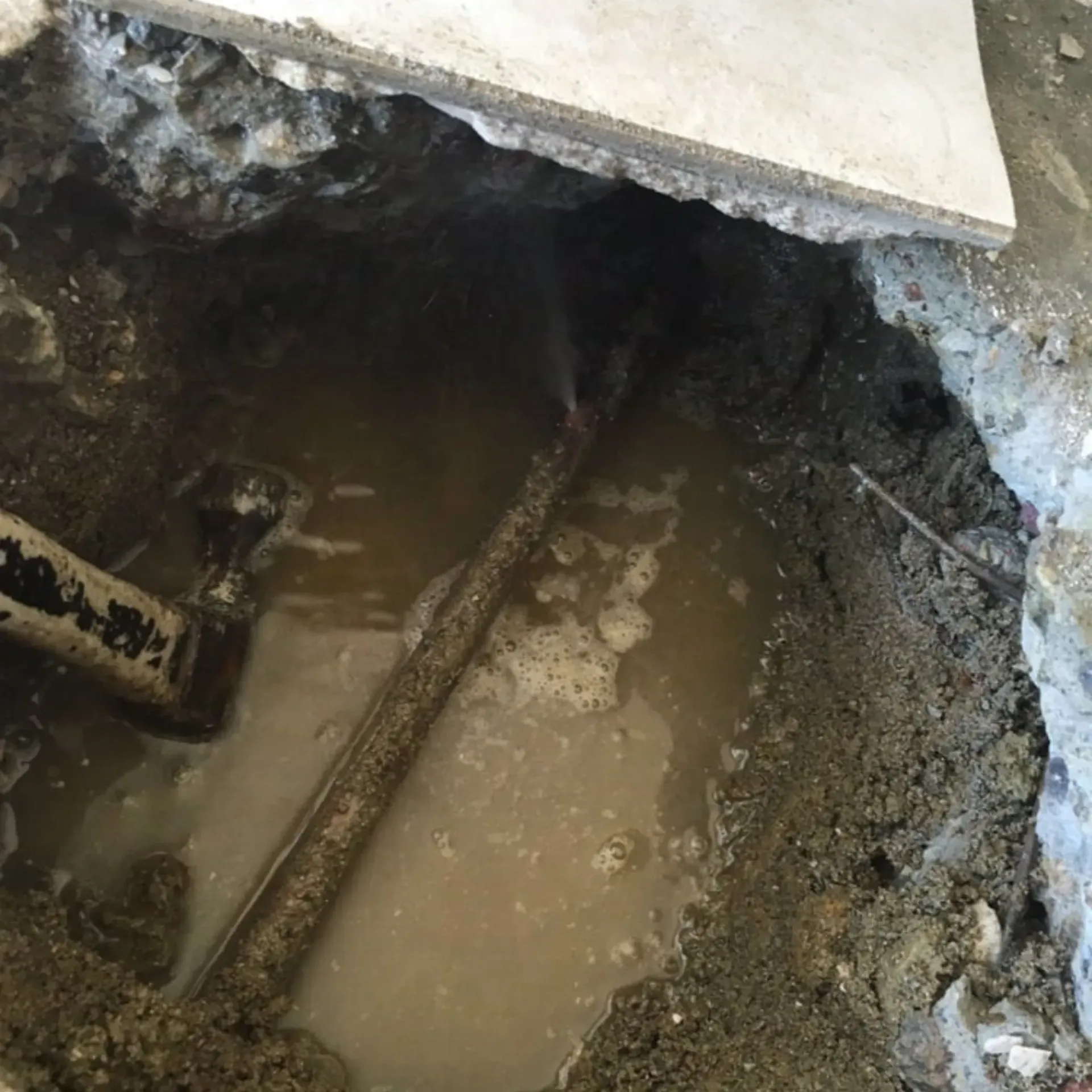 Ted & Bros Plumbing | hole in the ground with a pipe coming out of it