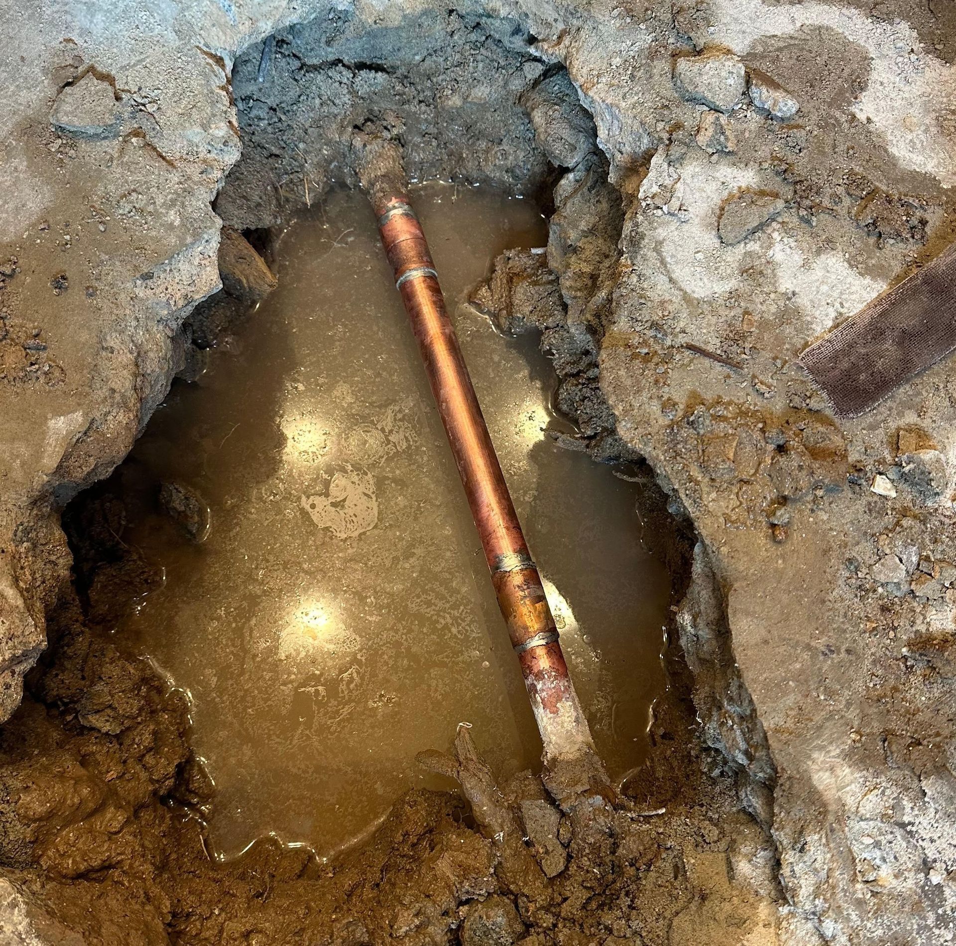 Ted & Bros Plumbing | hole in the ground with a pipe coming out of it