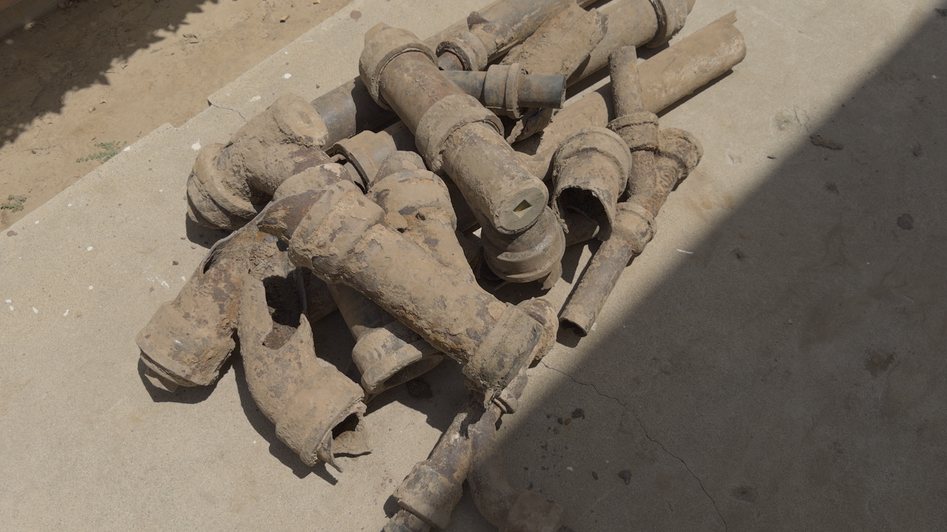 Ted & Bros Plumbing | bunch of pipes are laying in the dirt.