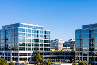 Modern glass office buildings under a clear blue sky