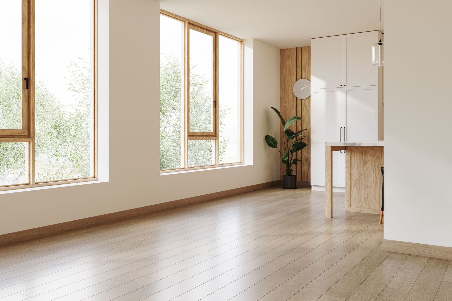 Bright empty room with large windows, light wood floors, and a small table by a plant.