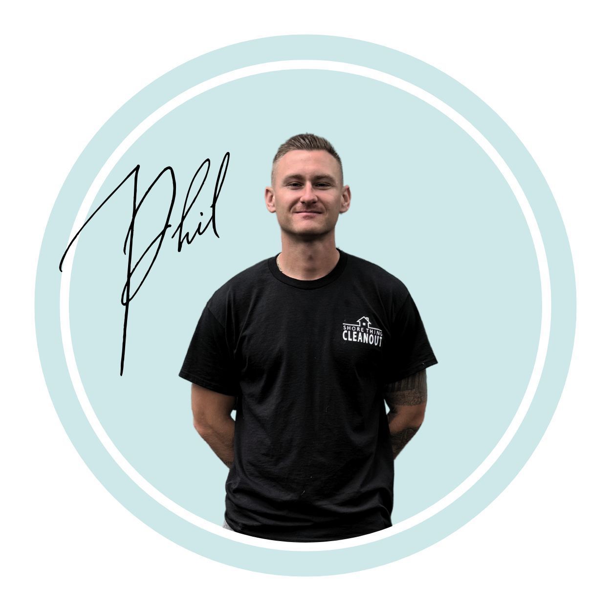 Man in black t-shirt with hands behind back, signature